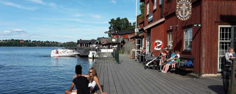 People relaxing by the water during Swedish summer.