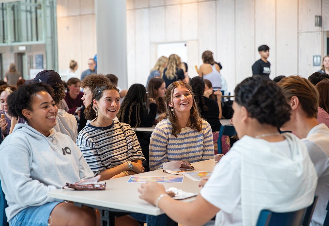 Students laughing together around a table at DIS Stockholm
