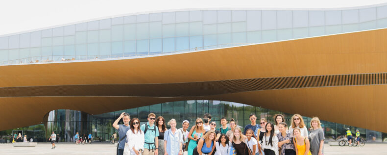 A group photo on a bright, summer day in front of Oobi Library in Helsinki.