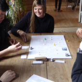 Four students playing a board game during study tour.