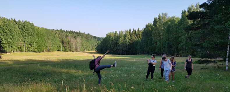Students having fun while walking through a green field in Finland.