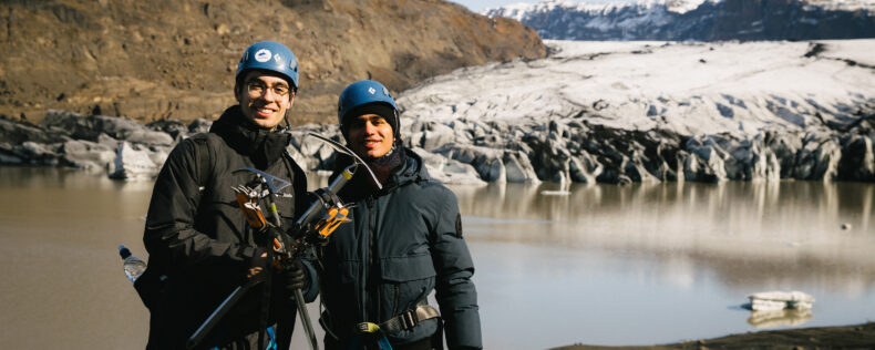 Students posing with hiking axes during an outdoor activity in the hills of Iceland.