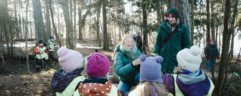 Students working with Finnish children in the forest.
