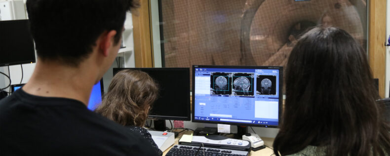 Two students and an instructor looking over a scan of the cat scan of the brain.