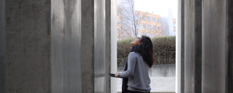 A student observing and taking notes at a memorial in Berlin.