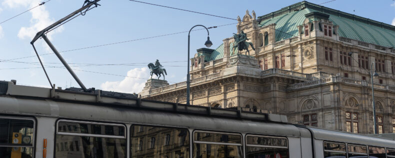 Vienna's tram, Wiener Linien, crosses in front of a historic Austrian building.