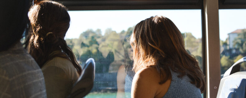 A student gracefully looking out of a bus window on a bright Portugal day.