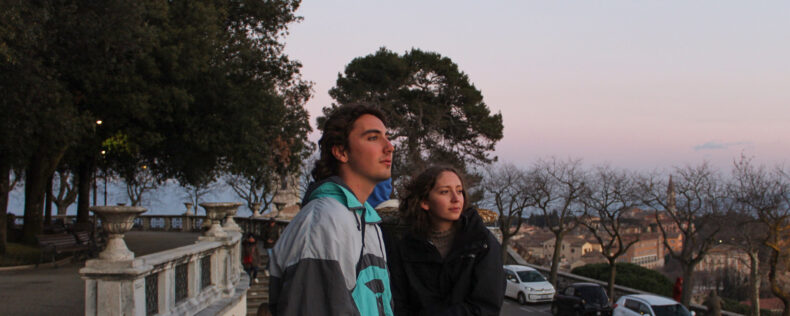 Two students observing the pink sky during sundown.