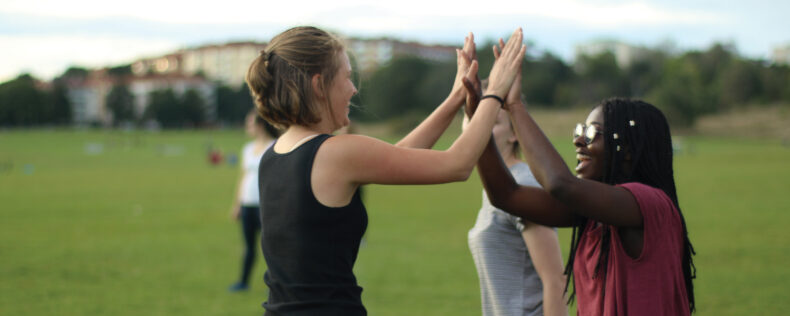 DIS students celebrating with a high-five during an athletic activity.